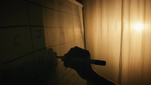 Silueta de mano marcando la fecha en el calendario