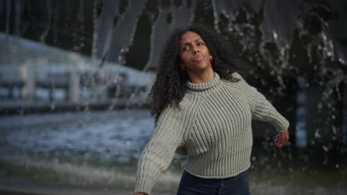 Woman Dancing Expressively in Front of Urban Fountain