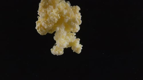 Bright Yellow Paint Spreading Underwater on Black Background