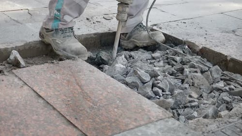 Jackhammer Breaking Concrete on Urban Sidewalk