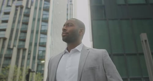 Black Business Male on Street looking at Urban Skyline