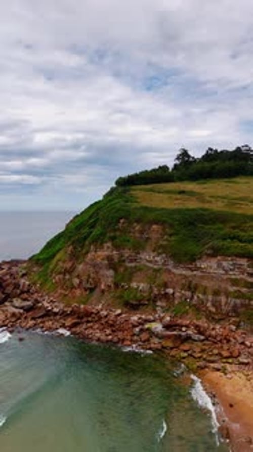 Steep rock with the flat top on the shore of the sea.