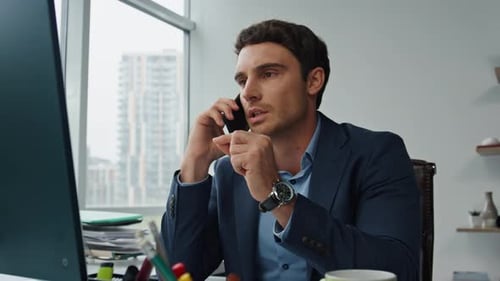 Focused Man Speaking on Phone in Office