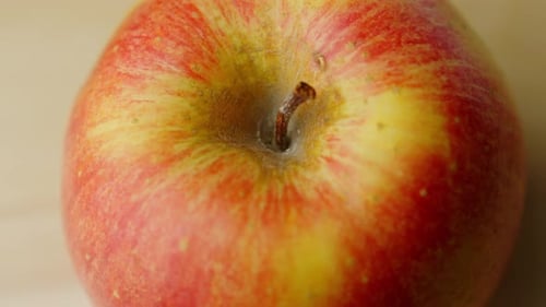 Closeup view of an organic red apple fruit rotating at fresh clean kitchen