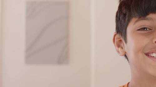 Smiling boy showing half face, close-up portrait in casual setting, copy space