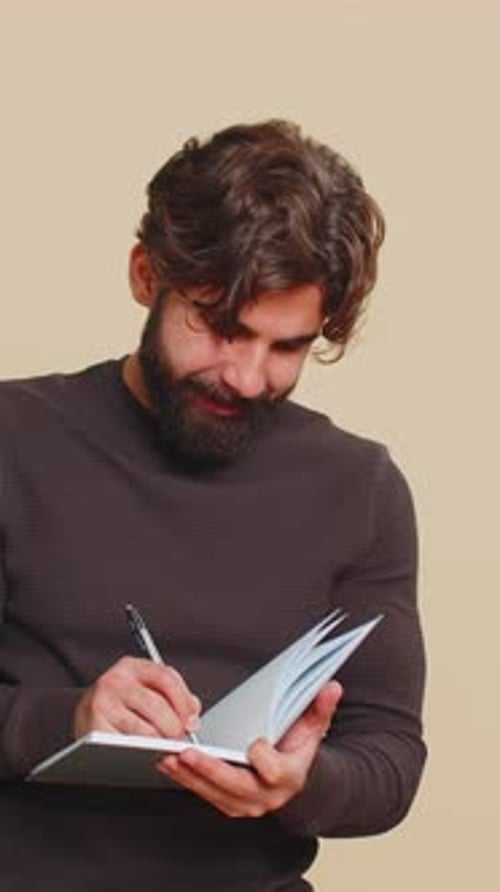 Young Adult Writing in Notebook with Pen