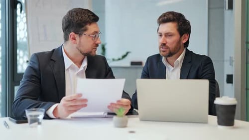 Focused Business Professionals Discuss Strategy in Office Meeting
