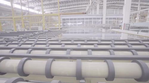 Industrielles Fabrikglas bewegt sich auf dem Rollgang. Automatische Entnahme von Flachglas vom Förderband