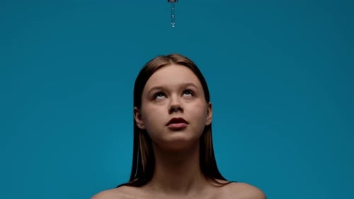 Close-up Young Adult Woman with Dropper on Blue