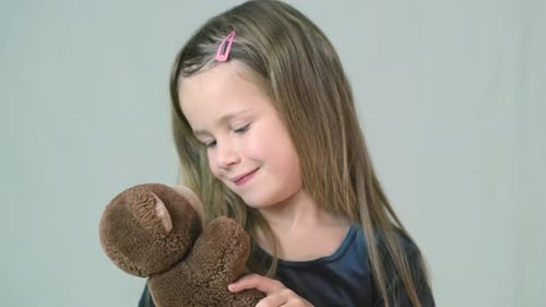 Happy Girl Cuddles Teddy Bear