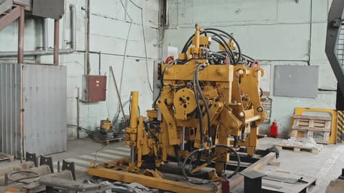 Large Yellow Machine Sitting Inside Industrial Workplace