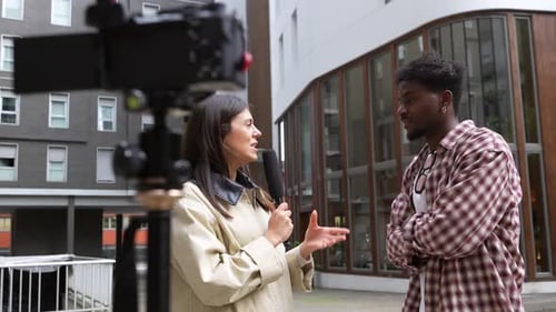 Journalistin interviewt jungen Mann auf der Straße für eine Sendung
