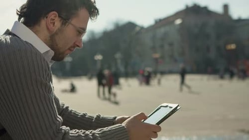Young Man Searching Information Using an Tablet Computer