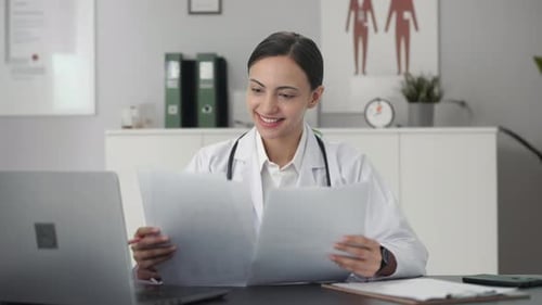 Happy Indian female doctor checking medical reports