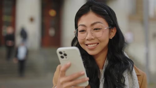 Cute Asian Business Woman Standing Outside in the Street Using Smartphone Happy Girl Scrolling