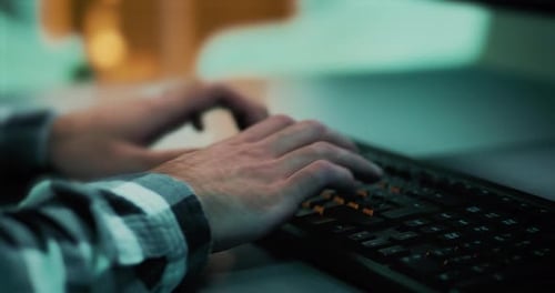 Close-up of a developer's hands working and writing code for a project using a computer keyboard. Wo