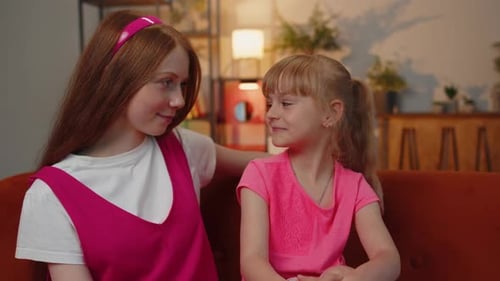 Smiling Child and Young Adult Sitting on Couch