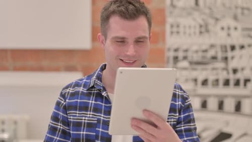 Portrait of Young Casual Man Doing Video Chat on Tablet