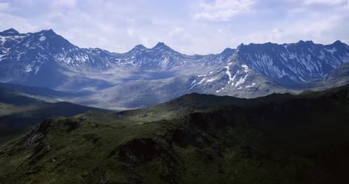 Majestic Mountain Landscape with Snow Capped Peaks Under Cloudy Sky