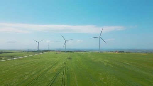 Wind Turbines Spinning in Green Field