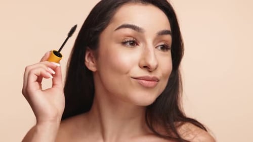 Beautiful Woman Applying Mascara, Smiling Confidently