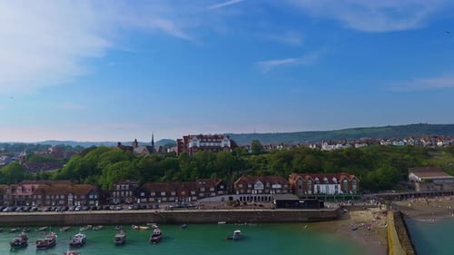 Seaside promenade buzzes with life at Folkestone pier. Coastal relaxation view