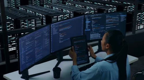 Side View Of Asian Woman Developer Working With Tablet While Write Code In Data Center