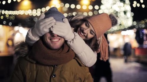 Romantic Couple Embracing at Outdoor Christmas Market at Night