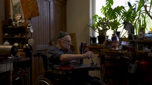 Mestre idoso trabalha em sua oficina restaurando a espada japonesa