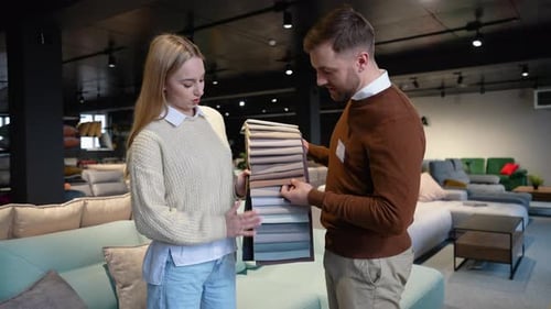 Woman and Man Select Upholstery in Furniture Showroom
