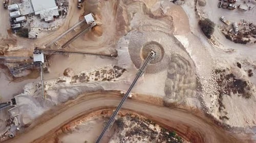 Luftaufnahme eines großen Steinbruchs während der Arbeitszeit mit Förderbändern zur Steinsortierung und einem Tagebau