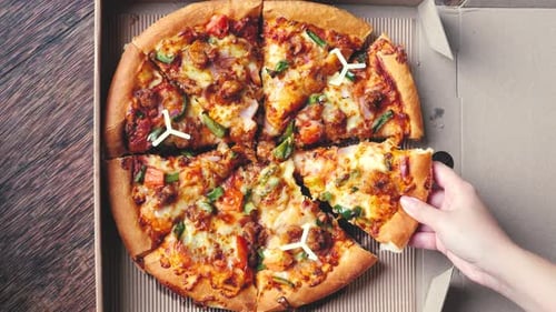 Hand Takes Slice of Pizza from Delivery Box