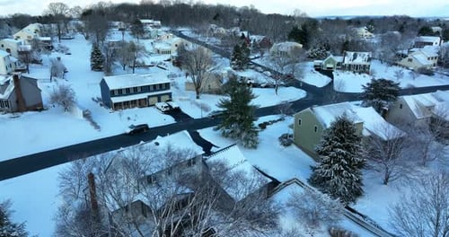 Backyard aerial view of winter snow. Duplex and Cape Cod single family homes in USA.