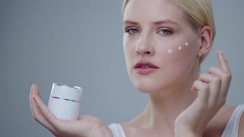 Woman applying facial cream for skincare routine
