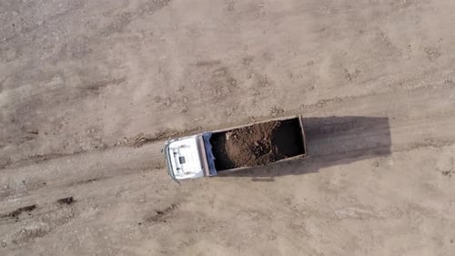 Large Truck hauling a full load of Excavated Soil on a dirt road.