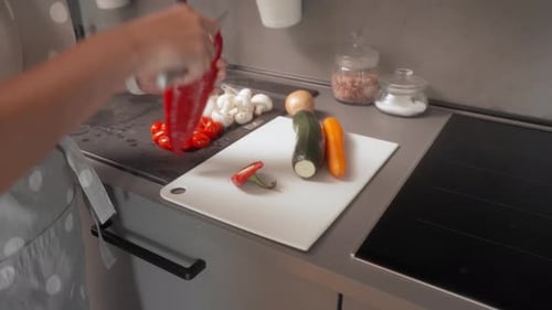 Woman Prepares Red Pepper in Kitchen