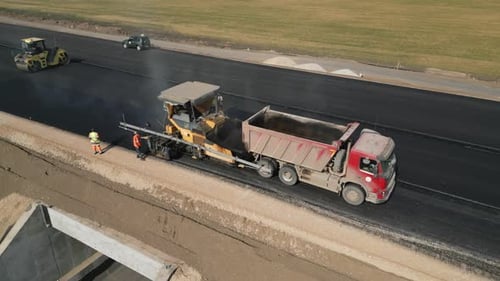 Asphalt Paver Laying Fresh Asphalt on New Road Clip