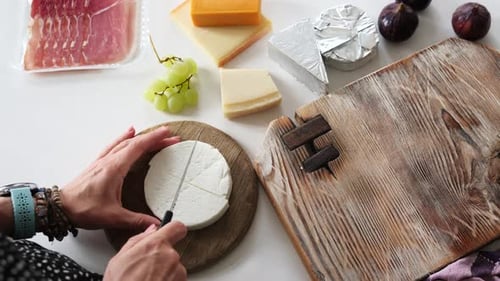Fille découpant du fromage sur une planche pour planche à fromage