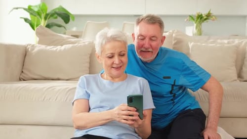 Happy Senior Couple Using Smartphone Together at Home