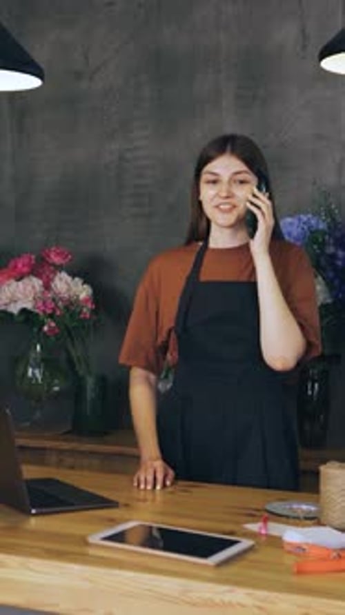 In a Charming Flower Shop a Skilled Florist Showcases Her Talent and Enthusiasm While Taking Orders