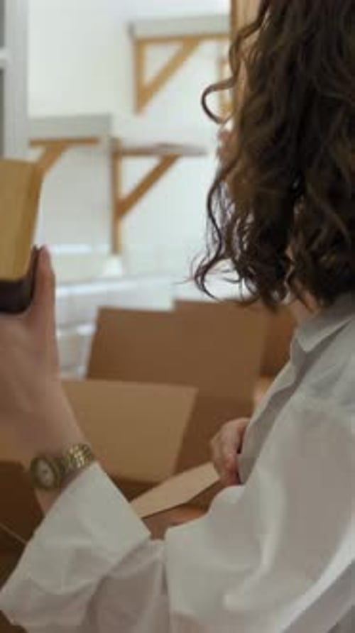 Vertical of Happy Couple Takes Kitchen Appliances Out of Paper Box