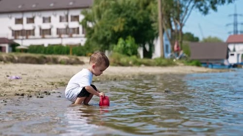Small boy on river beach playing. Water activity lifestyle.