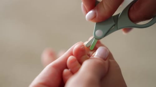 Adult Trimming Baby's Nails Close Up