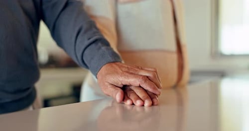 Closeup of couple, man and woman holding hands on table for love, care and trust together