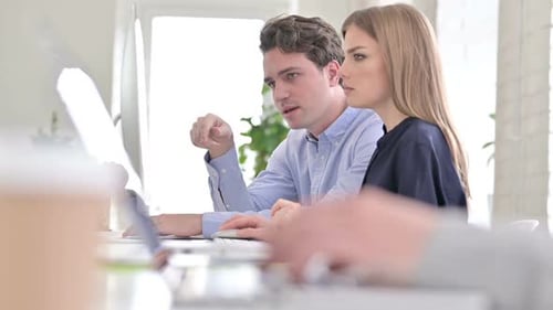 Close up of Serious Creative People Discussing and Working on Desktop