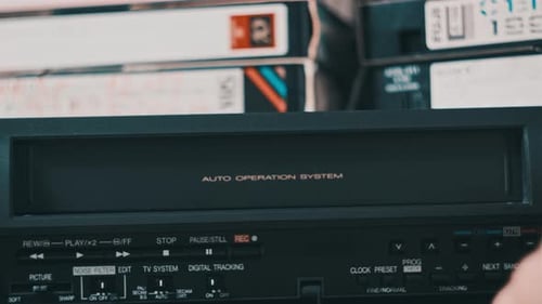 Hand Inserts VHS Tape Into Retro VCR Player