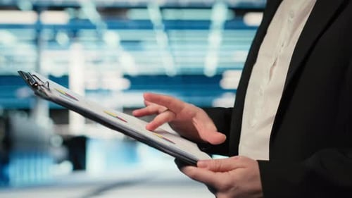 Close Up of Data Center Engineer Reading Clipboard Files Charts