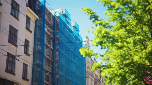 A Modern Building Facade is Currently Undergoing Renovation While Being Supported By Scaffolding