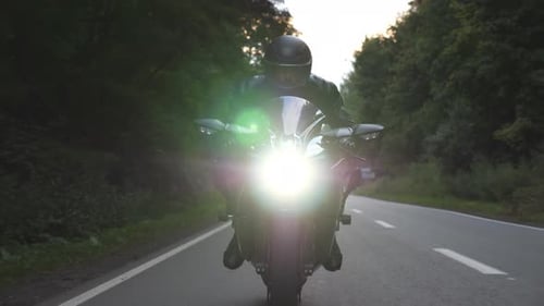 Biker Rides on Modern Motorbike at Woodland Rural Route Motorcyclist Travel at Motorcycle on Forest