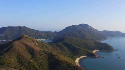 Cinematic drone shot traveling forward and upward of the coast of an island with some beach to revea